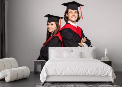 Portrait of two happy graduating students isolated over white background. Wall mural